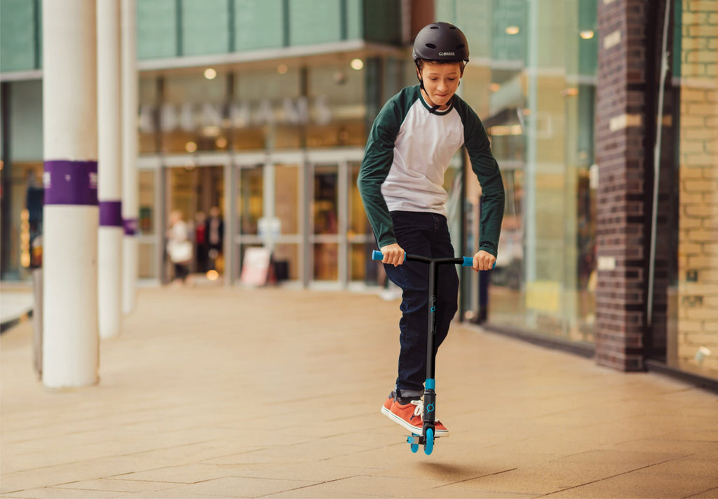 Niño andando en scooter agresivo Globber Stunt