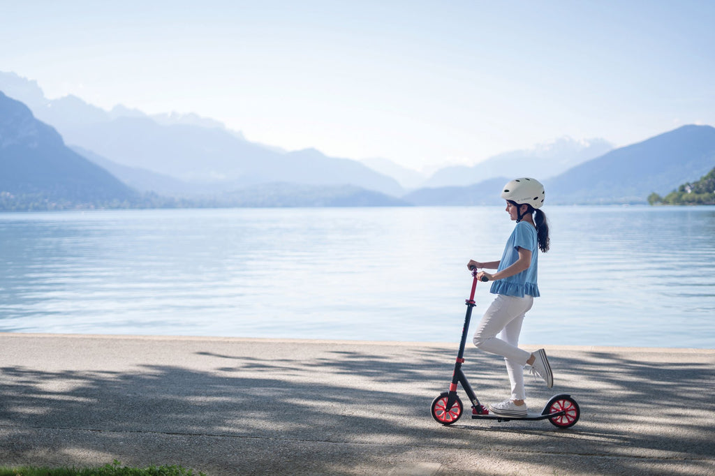 Joven en scooter Globber NL 205 junto al lago